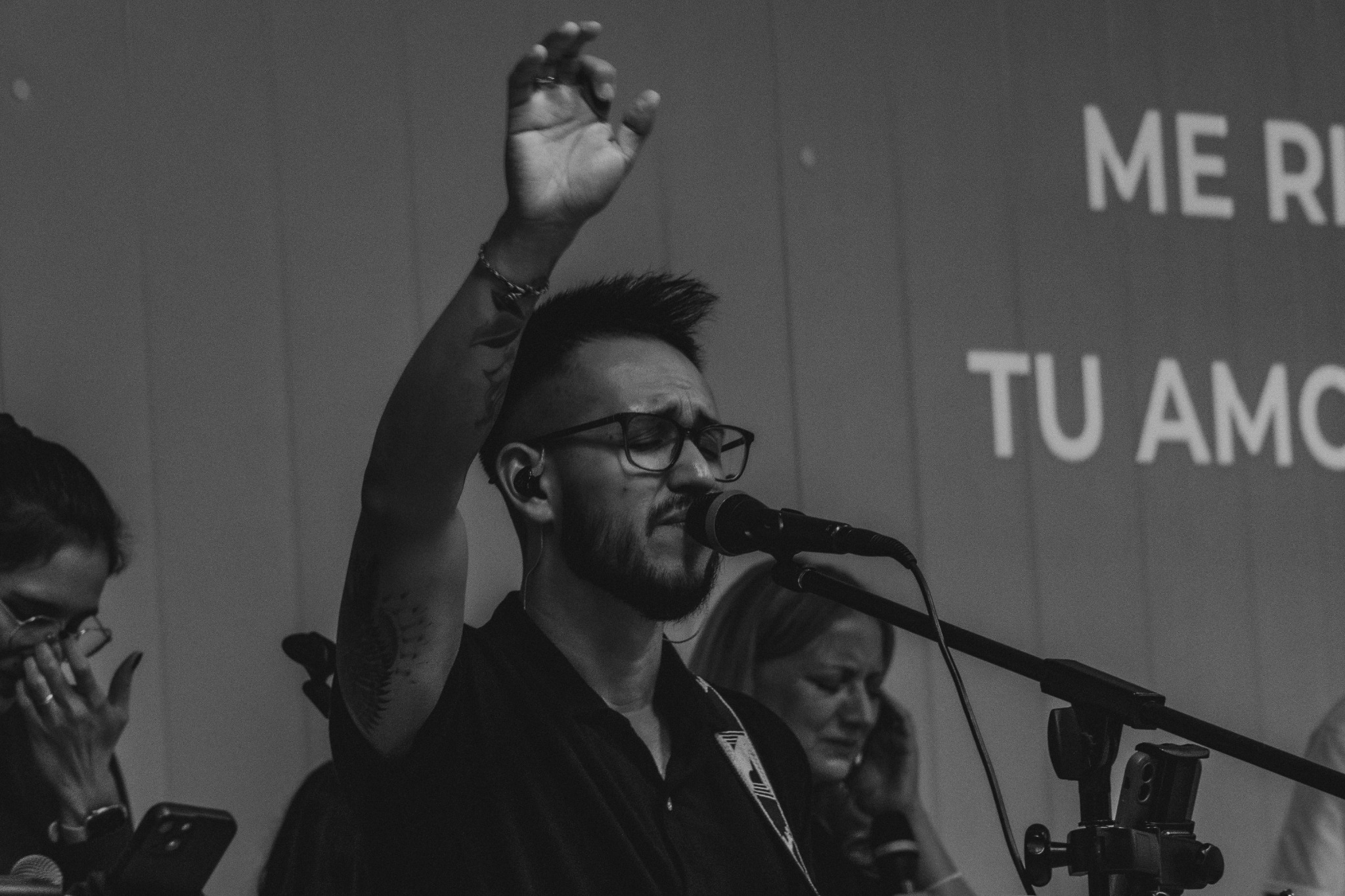 Un músico de la iglesia cantando y levantando la mano durante la alabanza